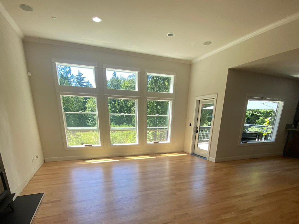 Clean slate living room, with huge windows, beautiful new hardwood floors, and fresh paint